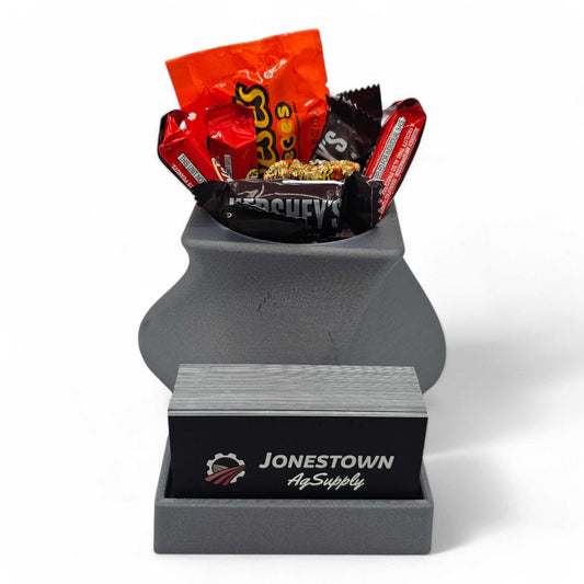 gray StyleLine Lite business card holder for desk with built-in compartment filled with assorted candy bars on white background