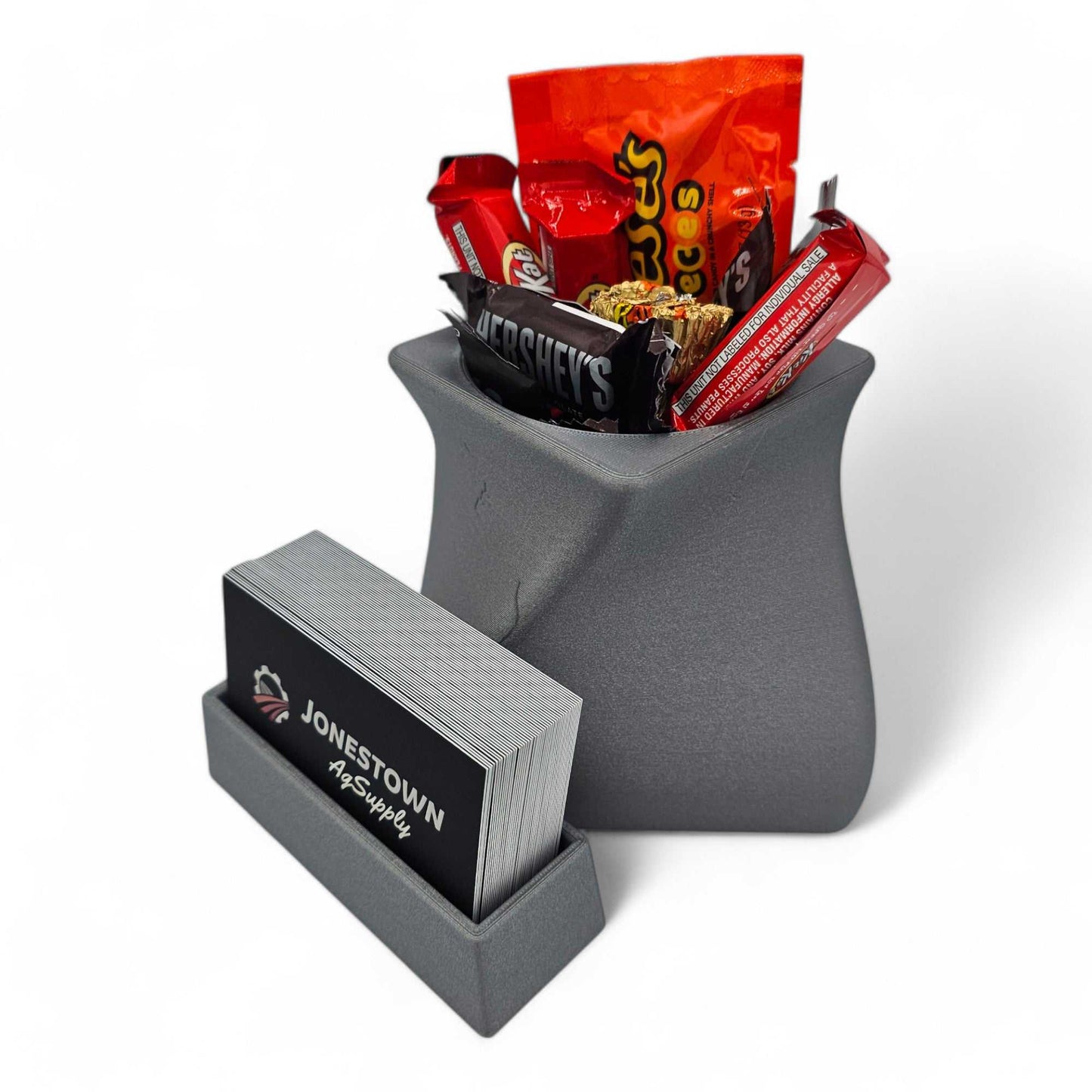 Gray StyleLine Lite business card holder for desk with attached compartment holding assorted candy bars and pens