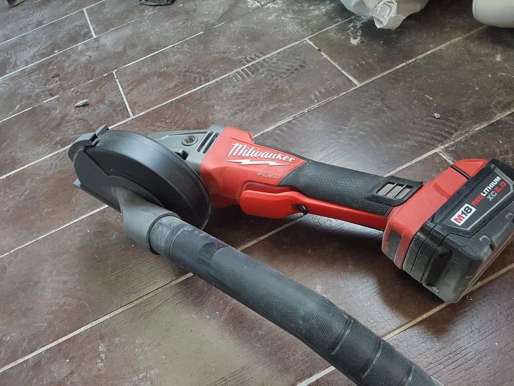 Milwaukee M18 Grinder with Dust Collection Adapter on wooden floor, Type 1 Guard compatible.