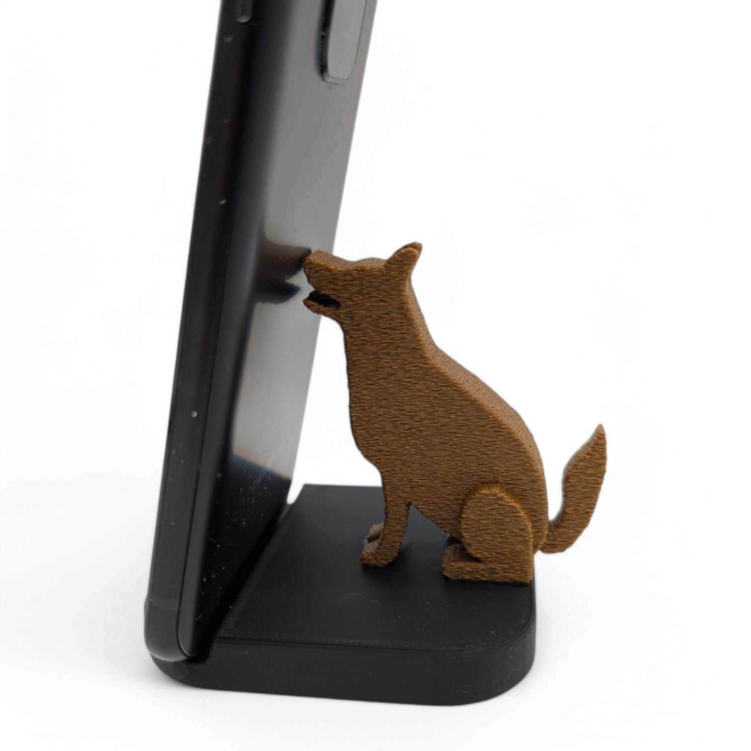 German Shepherd Dog phone stand holding a smartphone vertically on a black base with a brown dog figure.
